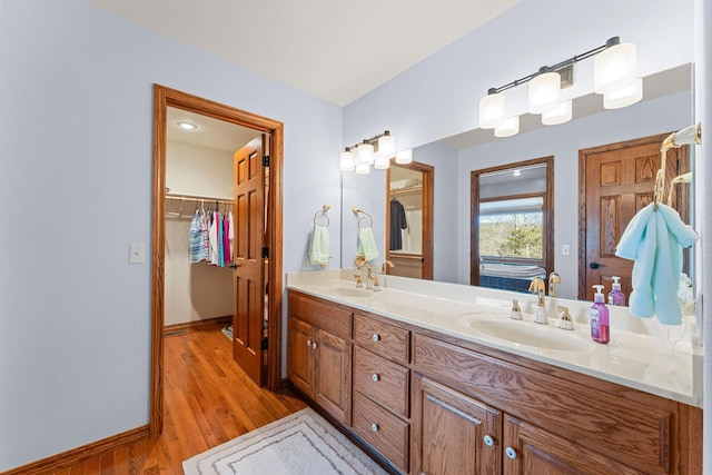 230 Temple Ln, Shell Knob, MO 65747 - bathroom with a walk in closet, wood finished floors, a sink, and double vanity