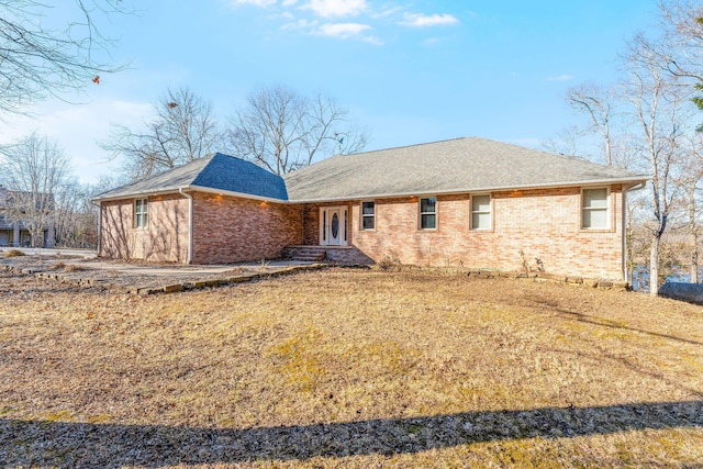 rear view of property featuring a yard, a shingled roof, french doors, and brick siding