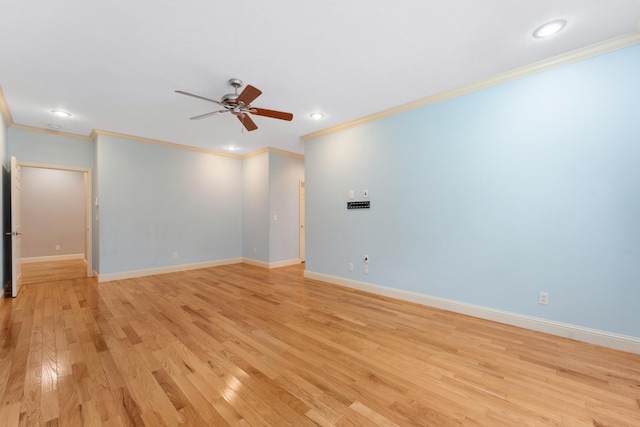 spare room with ornamental molding, light wood-type flooring, a ceiling fan, and baseboards