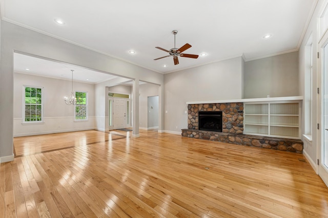 unfurnished living room featuring light wood-style flooring, recessed lighting, ceiling fan with notable chandelier, a fireplace, and ornamental molding