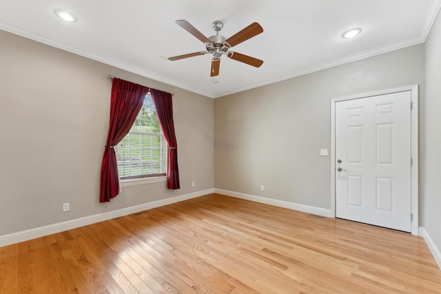 spare room featuring light wood-style floors, ornamental molding, baseboards, and ceiling fan