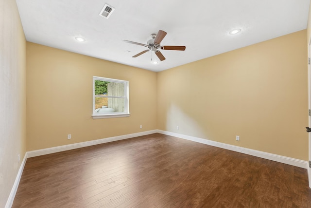 empty room featuring ceiling fan, dark wood-type flooring, visible vents, and baseboards