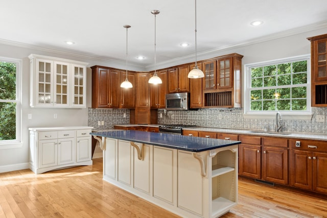 kitchen featuring tasteful backsplash, a kitchen breakfast bar, stainless steel appliances, open shelves, and a sink