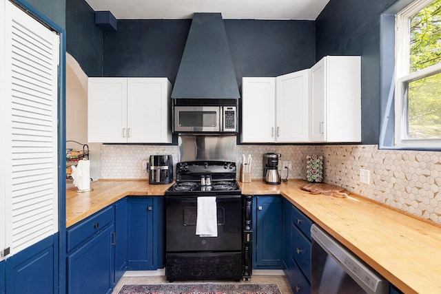 kitchen featuring blue cabinetry, butcher block counters, white cabinetry, and stainless steel appliances