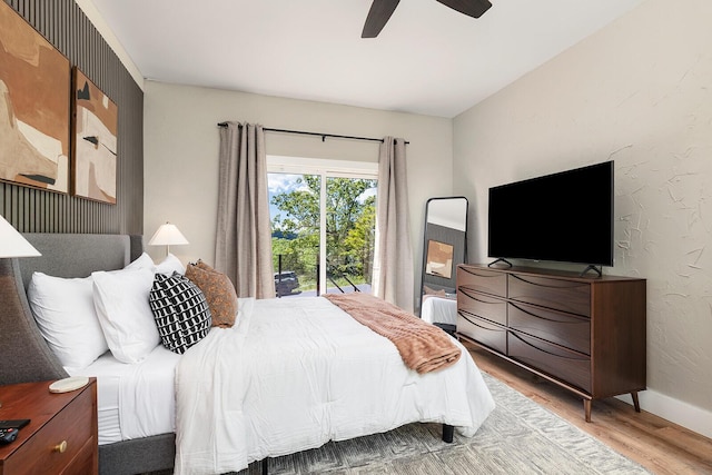 bedroom with a ceiling fan, baseboards, wood finished floors, and a textured wall