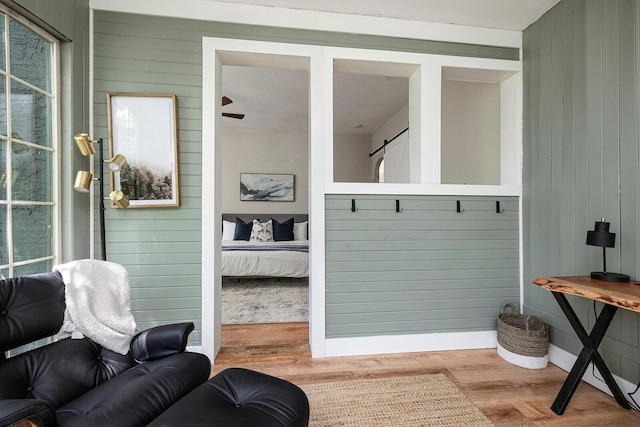 mudroom featuring wood walls and wood finished floors