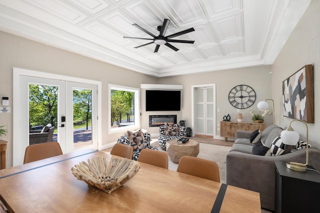 dining space with ceiling fan, french doors, a glass covered fireplace, and an ornate ceiling