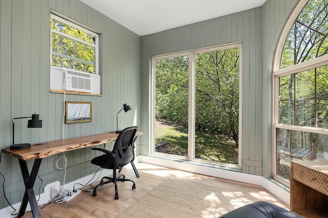 home office with cooling unit, a wealth of natural light, and wood finished floors