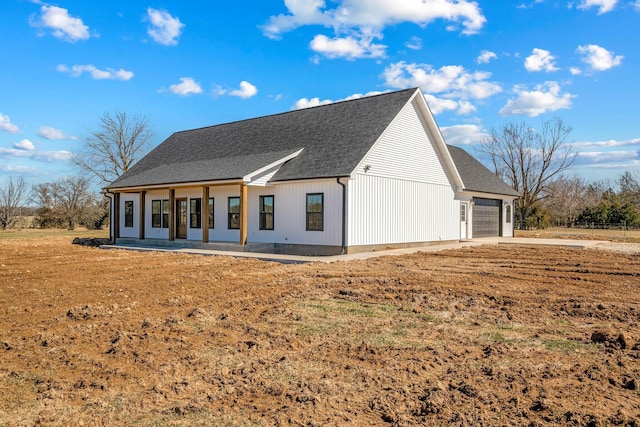 view of front facade with a garage and a shingled roof