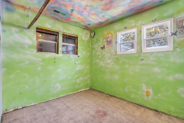 carpeted spare room featuring visible vents