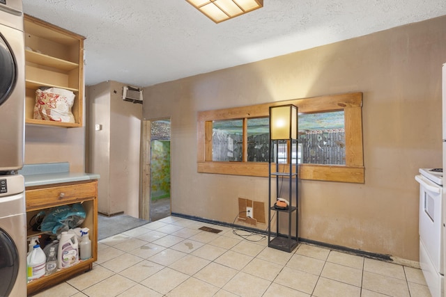 interior space featuring a textured ceiling, stacked washing maching and dryer, and light tile patterned floors