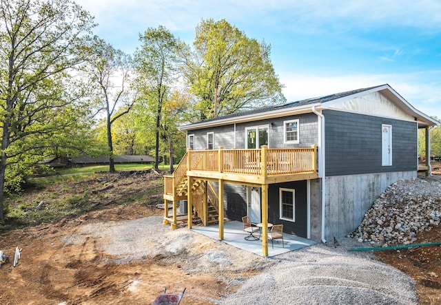 back of property with a deck, stairway, and a patio area
