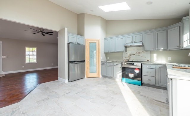 kitchen featuring stainless steel appliances, under cabinet range hood, high vaulted ceiling, a skylight, and open floor plan