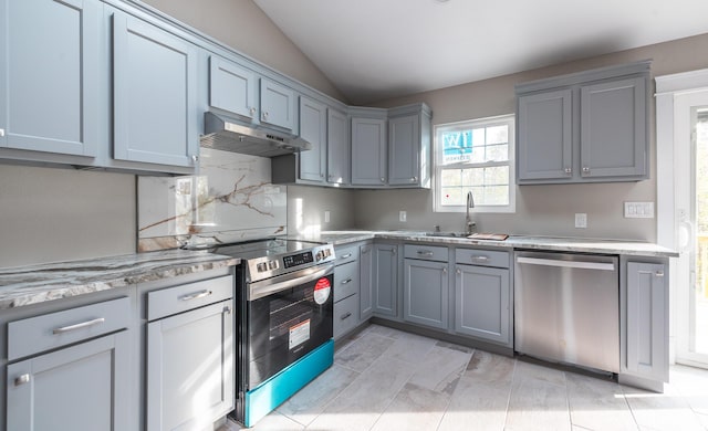 kitchen featuring under cabinet range hood, gray cabinets, appliances with stainless steel finishes, and a sink