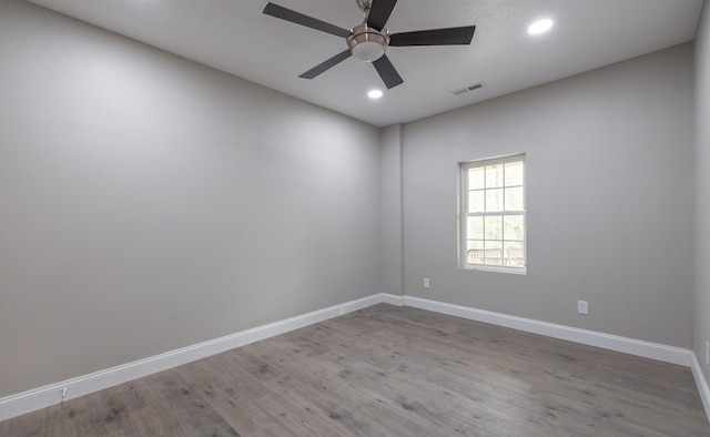 unfurnished room with visible vents, recessed lighting, wood finished floors, and baseboards
