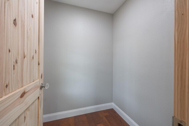 interior space featuring baseboards and dark wood-style flooring