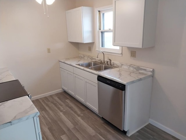 kitchen with a sink, white cabinetry, baseboards, light countertops, and dishwasher