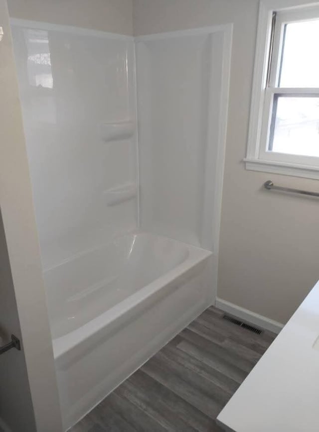 full bath with wood finished floors, visible vents, and baseboards