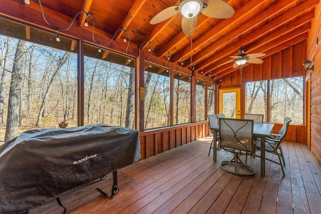 sunroom with lofted ceiling with beams, wood ceiling, and a ceiling fan