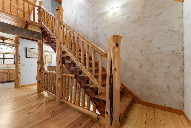 stairway featuring wood-type flooring and baseboards