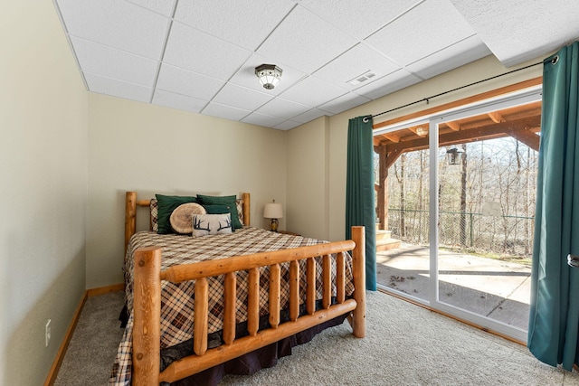 carpeted bedroom featuring baseboards, a paneled ceiling, visible vents, and access to exterior