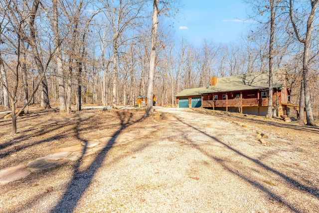 view of yard featuring a garage and dirt driveway