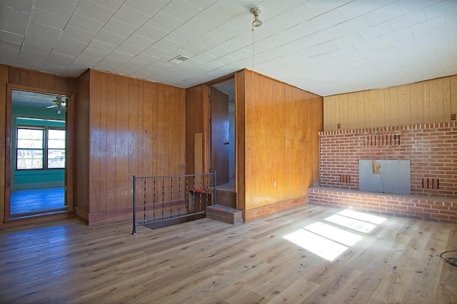 unfurnished room featuring wooden walls and wood finished floors