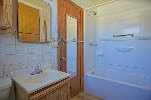 full bath with tile walls, tasteful backsplash, toilet, vanity, and  shower combination