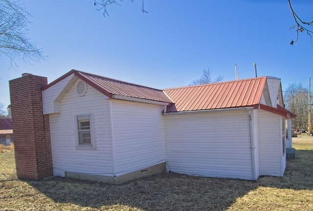 view of property exterior featuring metal roof, a chimney, and a lawn