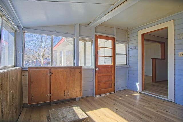 unfurnished sunroom featuring vaulted ceiling with beams