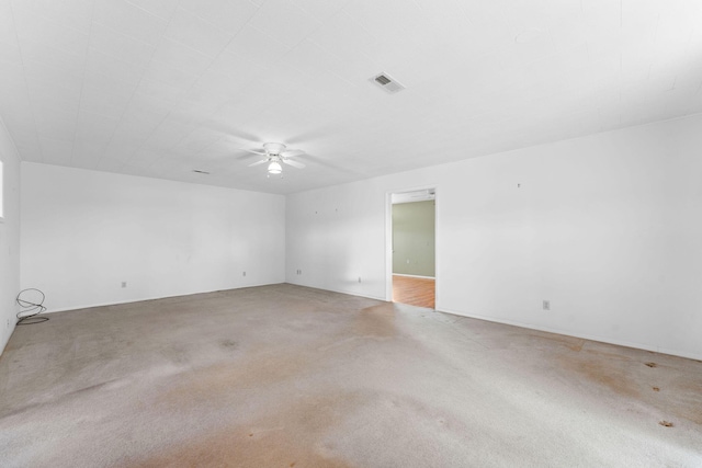 empty room featuring a ceiling fan, visible vents, and carpet flooring