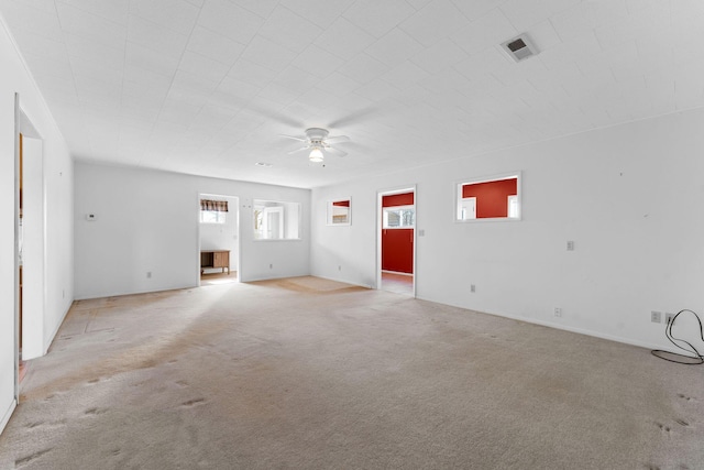 unfurnished living room with a ceiling fan, light colored carpet, and visible vents