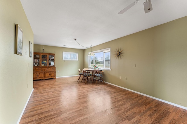 dining area featuring ceiling fan, wood finished floors, and baseboards