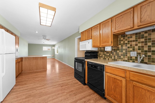 kitchen featuring ceiling fan, a sink, light countertops, black appliances, and light wood finished floors