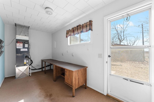 carpeted office featuring baseboards and heating unit