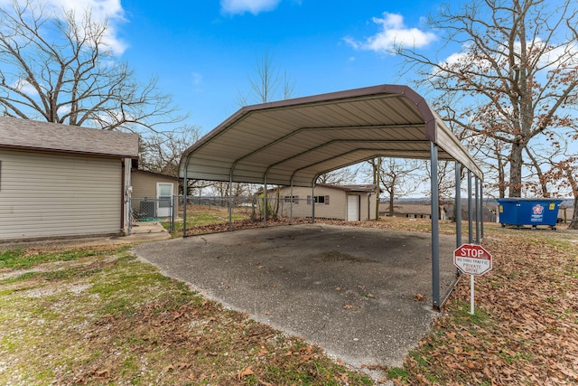 view of car parking with a detached carport, a gate, and fence