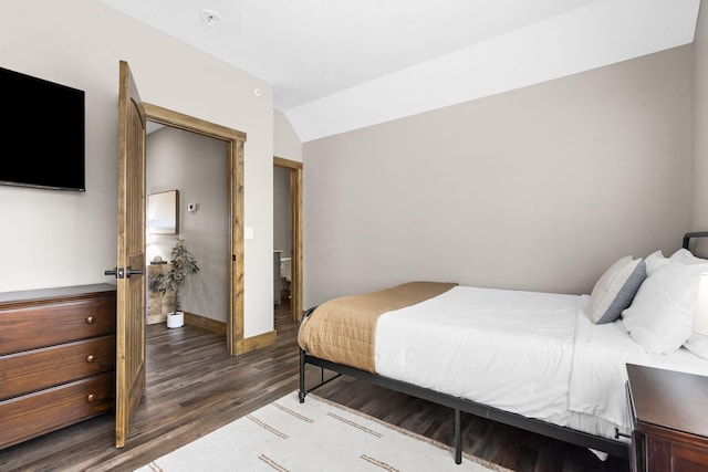 bedroom with lofted ceiling, baseboards, and wood finished floors