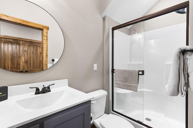 full bath with toilet, a textured wall, a stall shower, and vanity