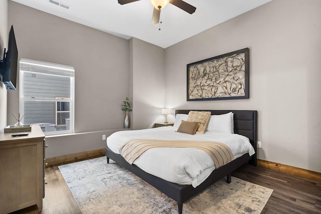 bedroom with wood finished floors, visible vents, and baseboards