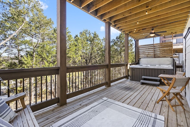 wooden deck with a hot tub and a ceiling fan