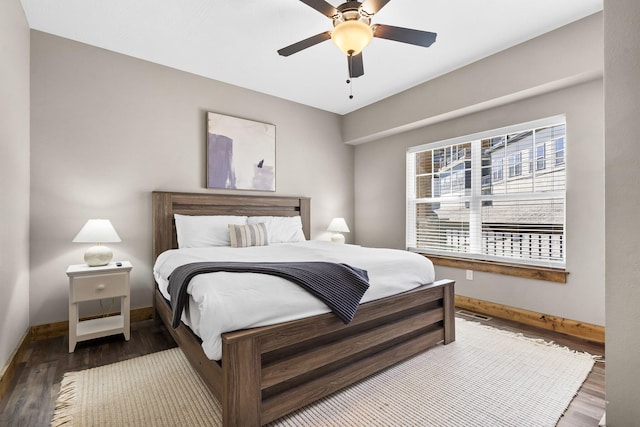 bedroom featuring ceiling fan, baseboards, and wood finished floors