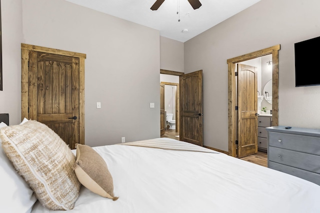 bedroom with wood finished floors, a ceiling fan, and ensuite bathroom