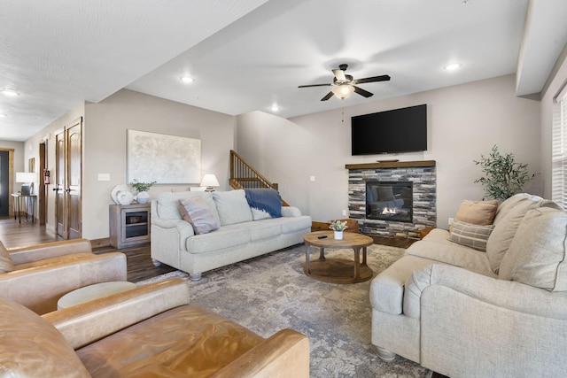 living room featuring a fireplace, recessed lighting, stairway, ceiling fan, and wood finished floors