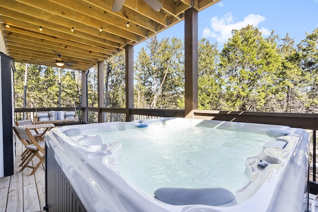 deck featuring outdoor dining area and a hot tub