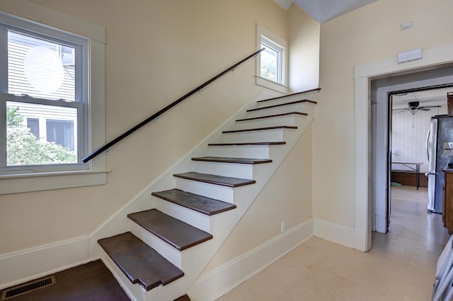 staircase featuring a wealth of natural light, visible vents, and baseboards