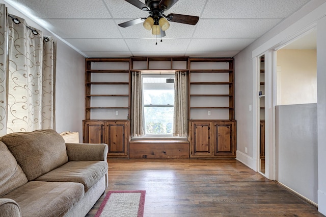 living room with a paneled ceiling, ceiling fan, and wood finished floors