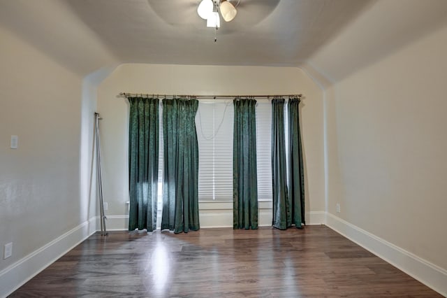 empty room with lofted ceiling, wood finished floors, a ceiling fan, and baseboards