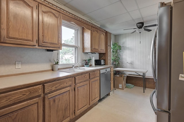 kitchen with stainless steel appliances, brown cabinetry, and a sink