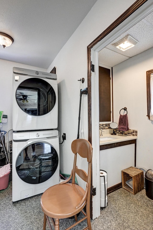 laundry area with a sink, visible vents, carpet flooring, and stacked washer and clothes dryer