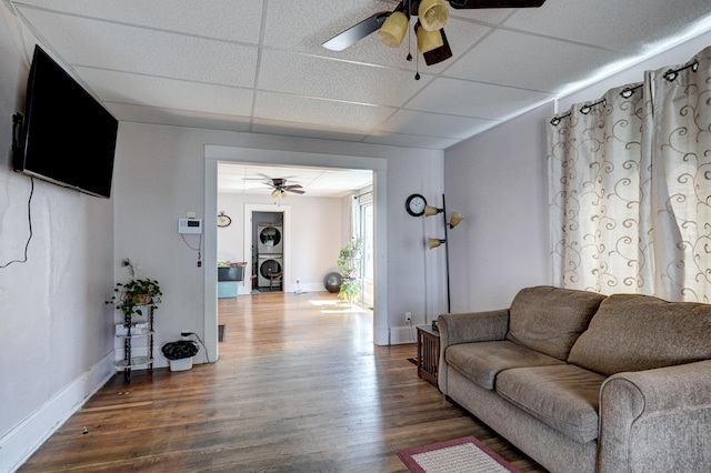 living area featuring a paneled ceiling, ceiling fan, baseboards, and wood finished floors